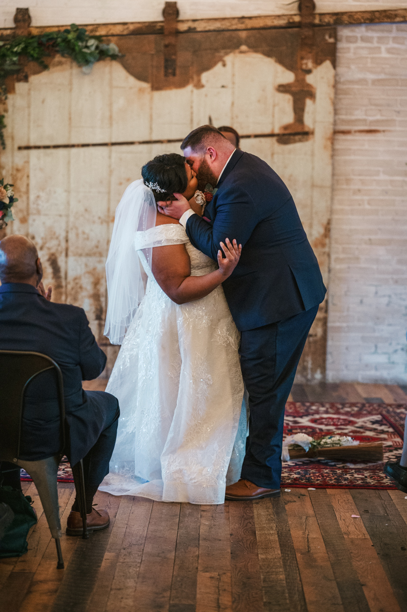 bride and groom kissing inside of Journeyman Distillery in Three Oaks Michigan